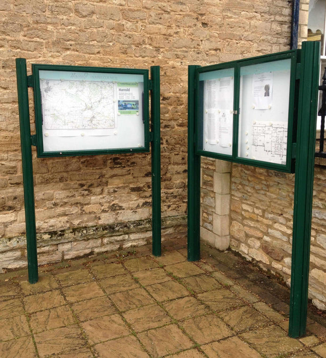 Two green landscape notice boards with posts